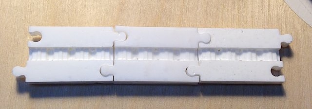 Three sections of plastic forming a timing belt mold