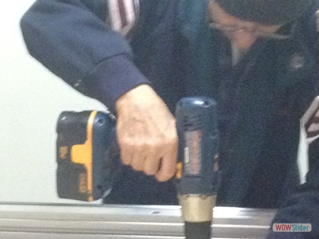 Larry screwing the sacrificial board to the CNC table