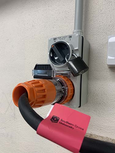 The main power switch is protected by a padlock, so that only trained staff can start up the router and supervise students