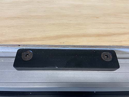 The metal bar and metal corner help aligning material on the work bench.