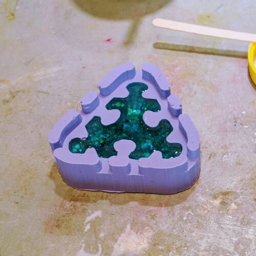 Casting a puzzle piece with blue glitters