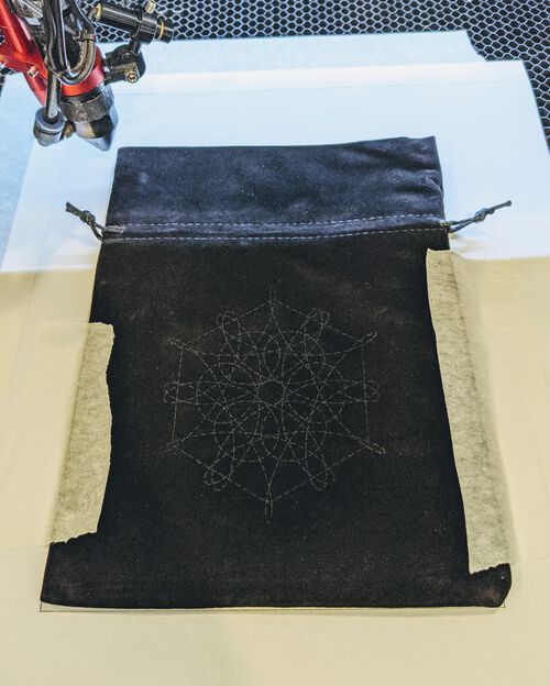 Laser cutting the spirograph and hexagon design into the bag