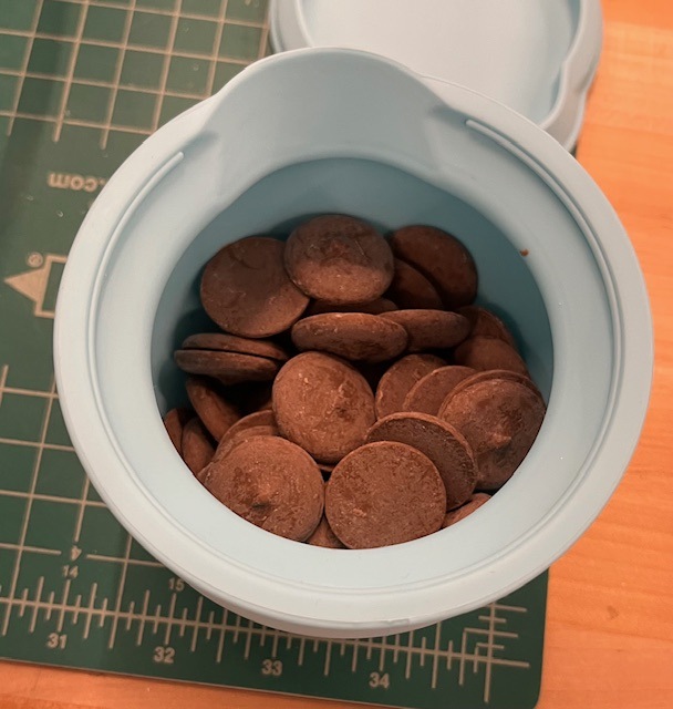 Chocolate candy wafers in blue silicone container