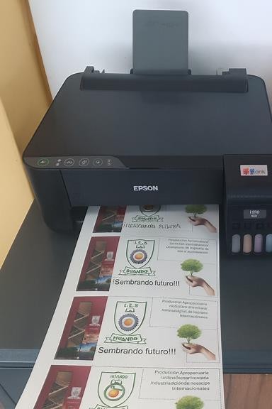 Editar la imagen de la impresora Epson EcoTank L3210 para que en lugar de la hoja con logos de 'FAB ACADEMY 2023 PERU' aparezca la hoja promocional del IES Huando con los textos en español: 'Producción Agropecuaria', 'Industrias Alimentarias', 'Administración de Proyectos', 'Informática' y 'Sembrando futuro!!!'.