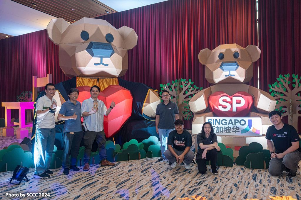 Project team gathered with the large graduation bear and SP mascot bear