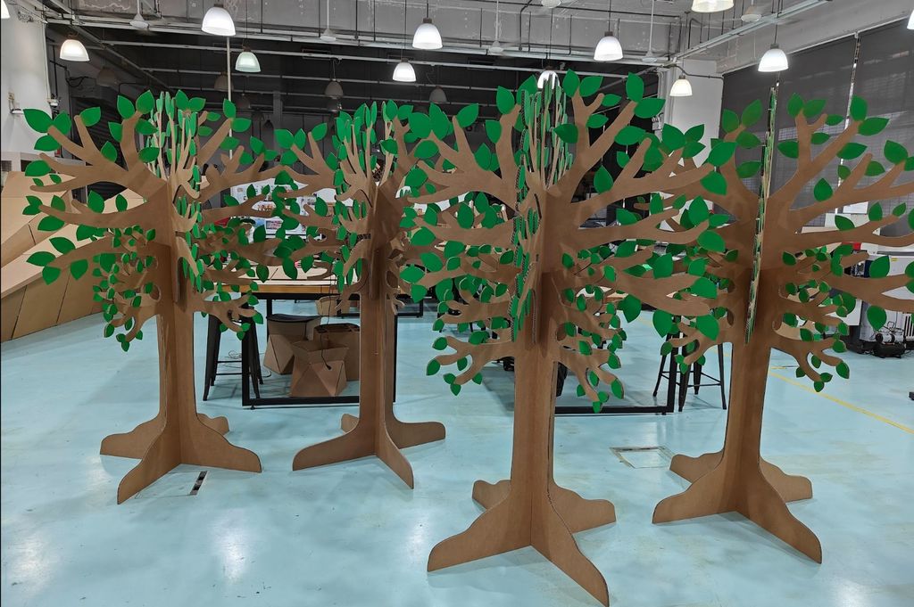 A group of freestanding cardboard trees assembled in the Fablab