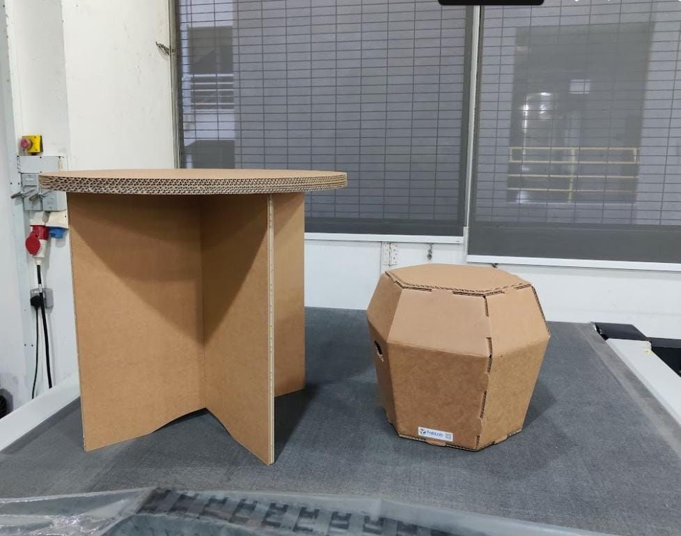 Plain cardboard table and stool prototypes assembled in the Fablab