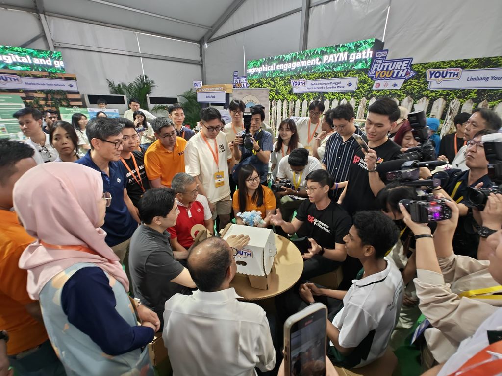 Students presenting handmade cardboard models to national leaders and the media