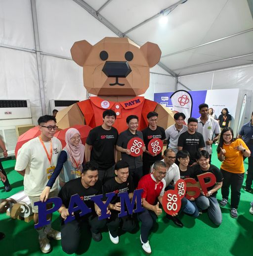 Students and guests gathered in front of the SG60 cardboard bear installation