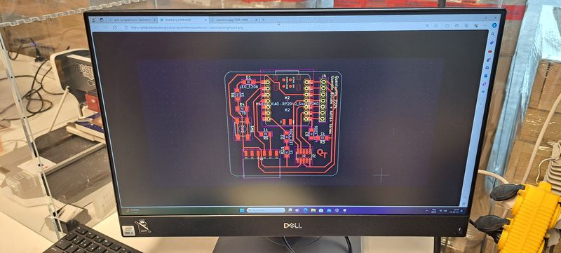 Picture of the board design file opened on a computer screen nearby.