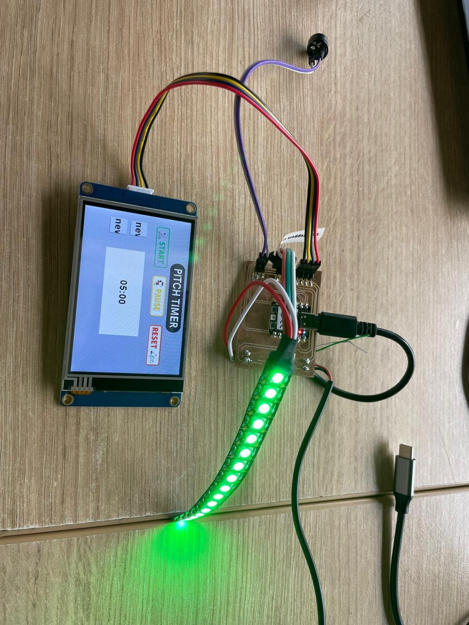 pitch timer fully operational — Nextion display showing PITCH TIMER 05:00, WS2812B LED strip glowing green, milled PCB with XIAO RP2040