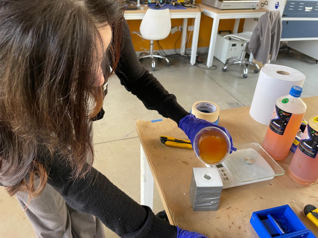 Mixing the resin components on the scale with nitrile gloves — Fab Lab setting