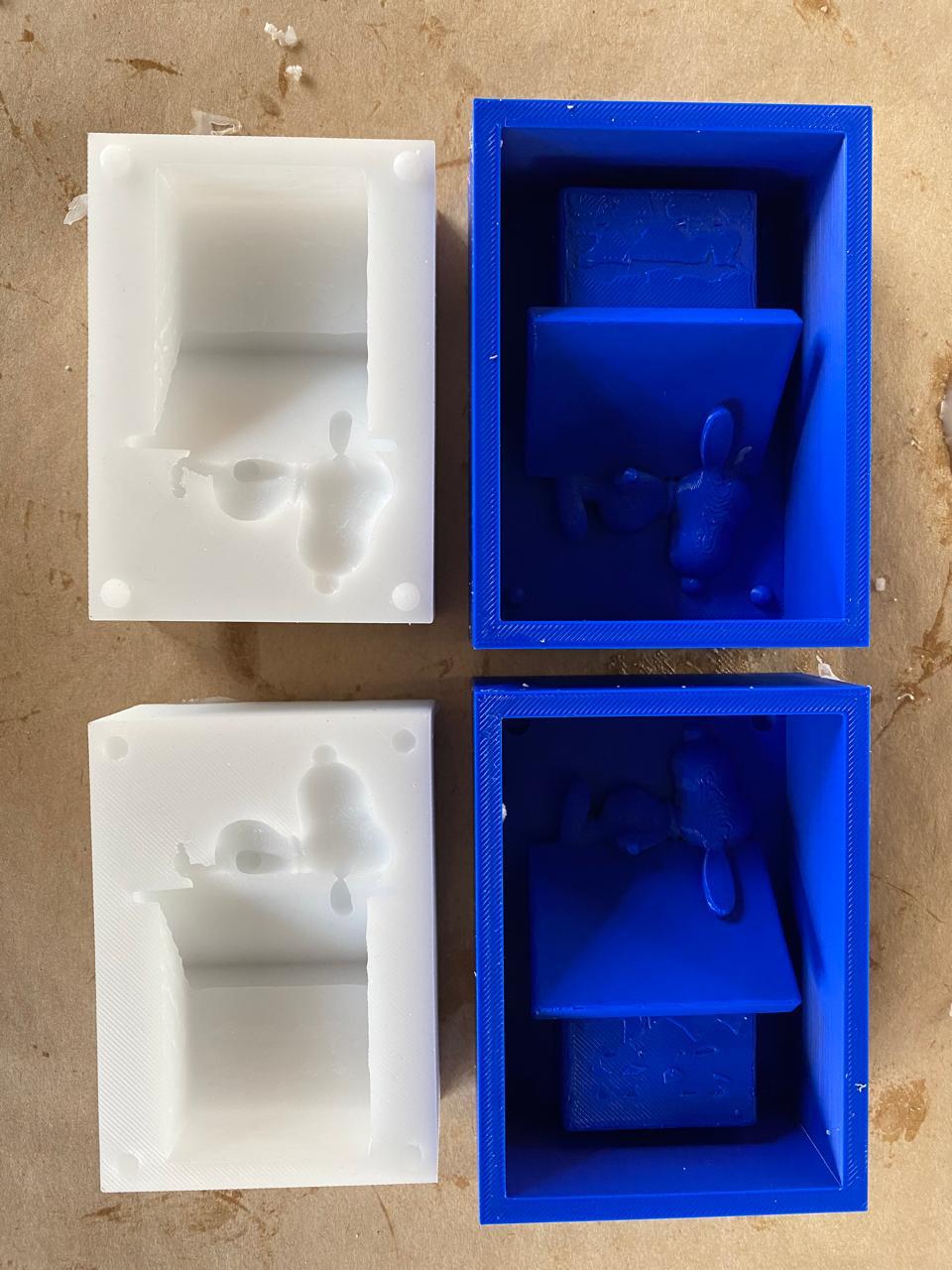 Comparison of silicone mold halves (white, left) and 3D-printed mold containers (blue, right) — two pairs shown