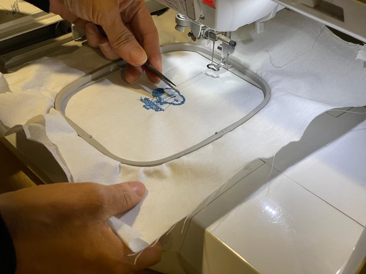 Inspecting the finished embroidery up close at the workstation