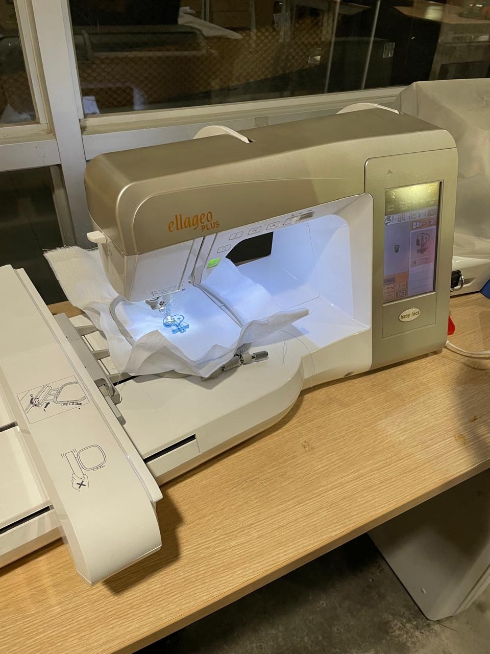 Monitoring the embroidery run — checking the hoop and design while the machine works