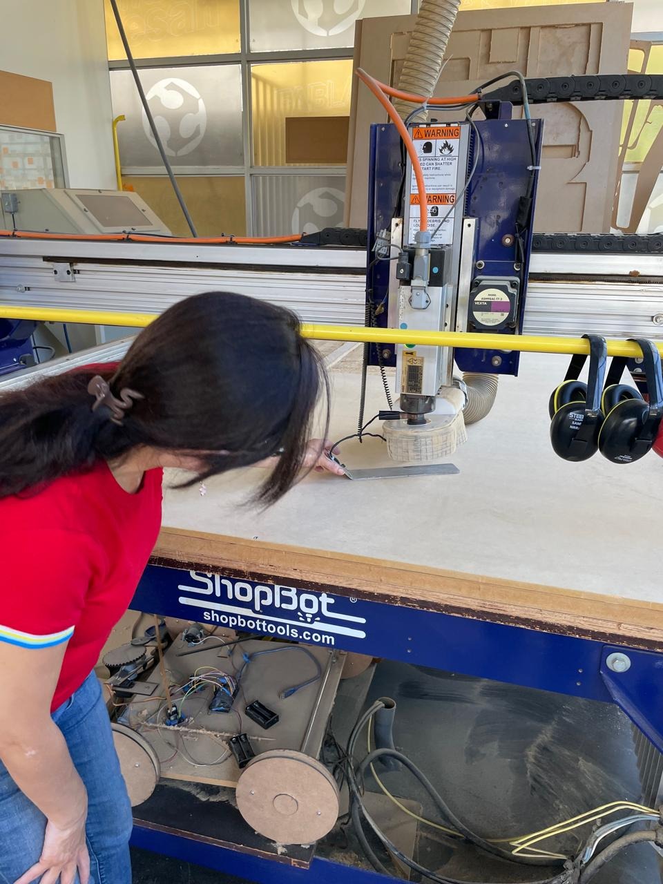 Marita at the ShopBot — checking the Z-zero position on the material surface
