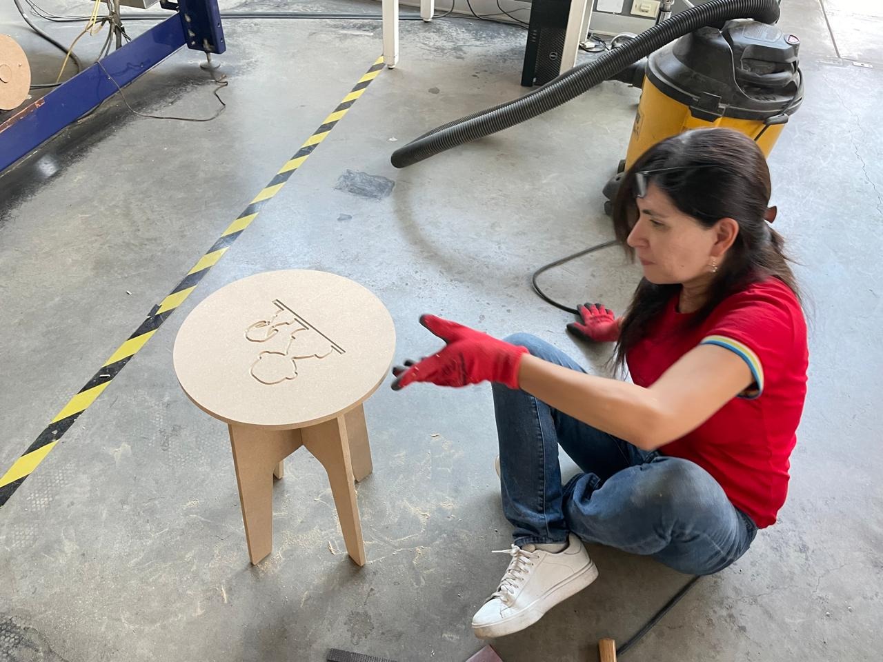 Marita pointing at the assembled Snoopy bench from above — V-carved top visible