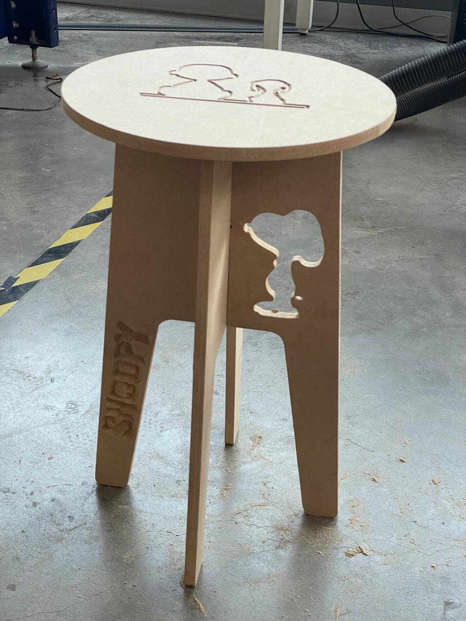 Assembled Snoopy bench — angled view showing the circular top with V-carved Snoopy illustration and the cut-through side panel