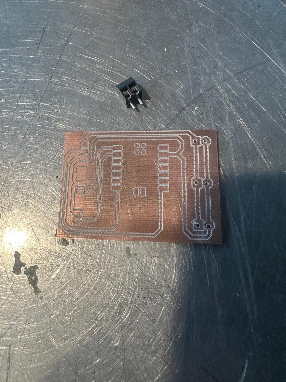 Freshly milled pitch timer PCB on the workbench — isolation channels visible, connector for scale