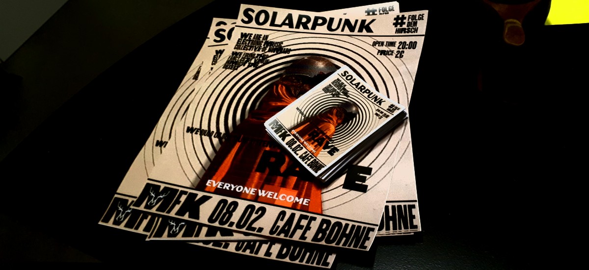 posters with the words “solarpunk” and “rave” lying on a table