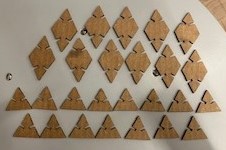 Several cardboard triangles and diamonds with slots that were laser cut