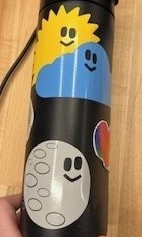 Cartoon moon, sun, and cloud stickers on a waterbottle