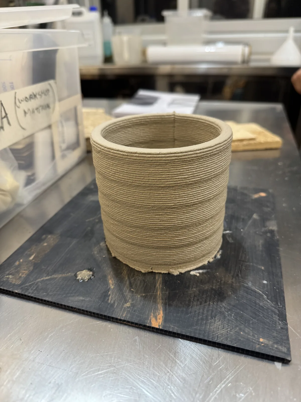 Finished clay printed cylindrical vessel showing even horizontal coil layers