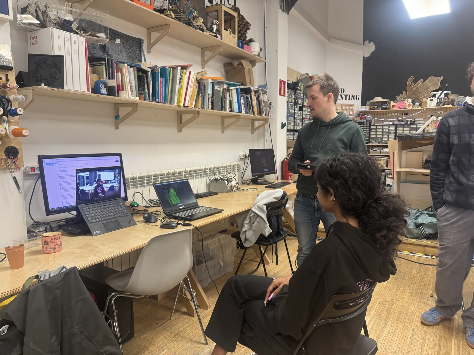 Group at a lab bench reviewing a green 3D scan on a laptop