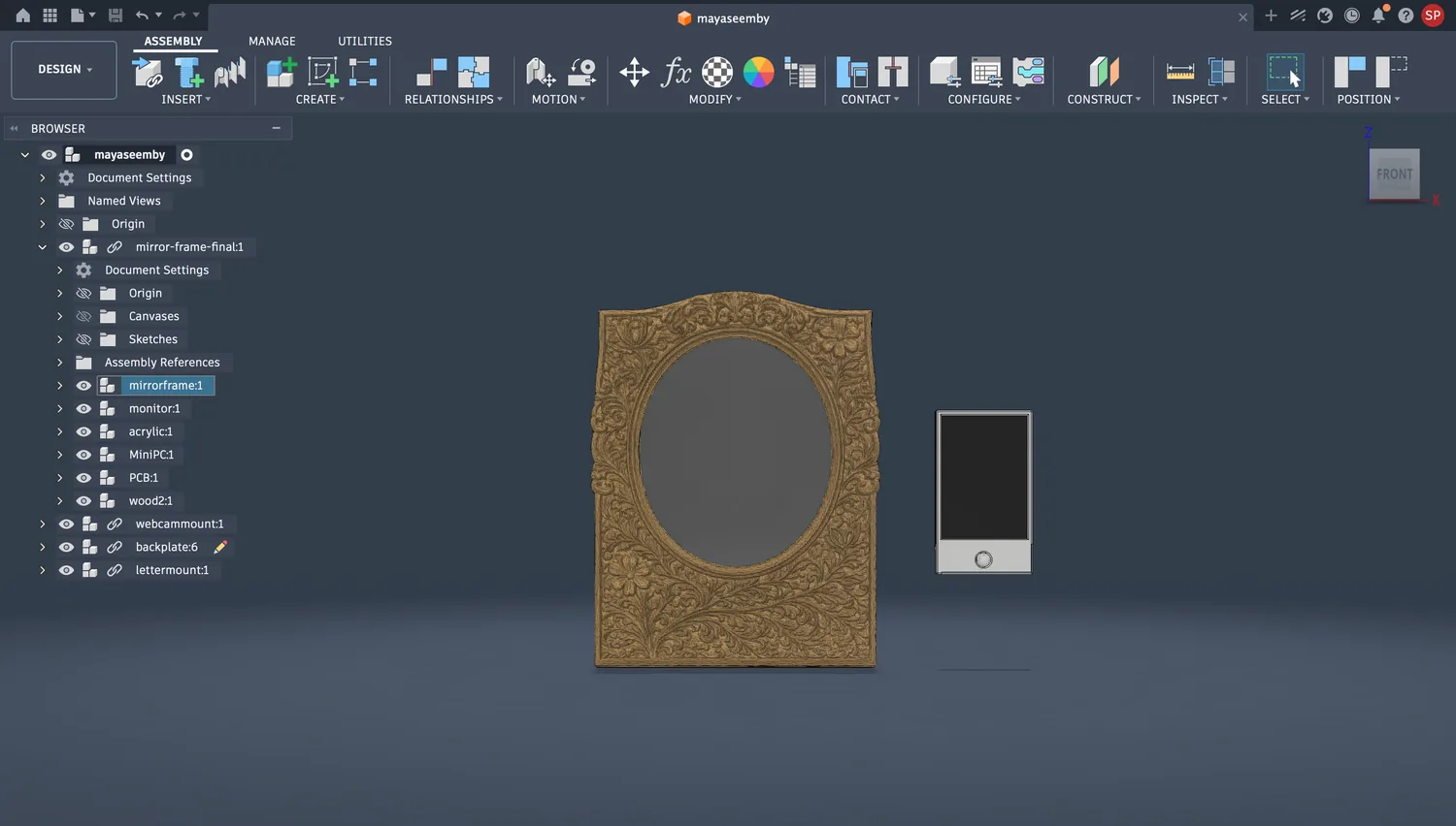 Fusion 360 front view of the assembly: the full carved botanical frame around the oval mirror, with the letter box beside it