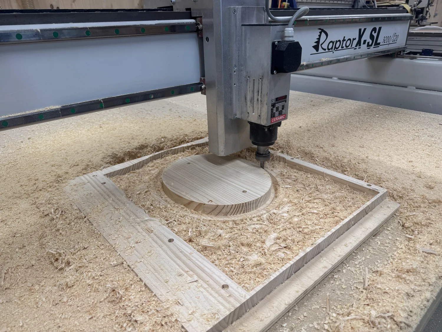 The CNC-STEP Raptor X-SL 3200/S20 router cutting the oval pocket and frame outline into the pine blank, chips everywhere