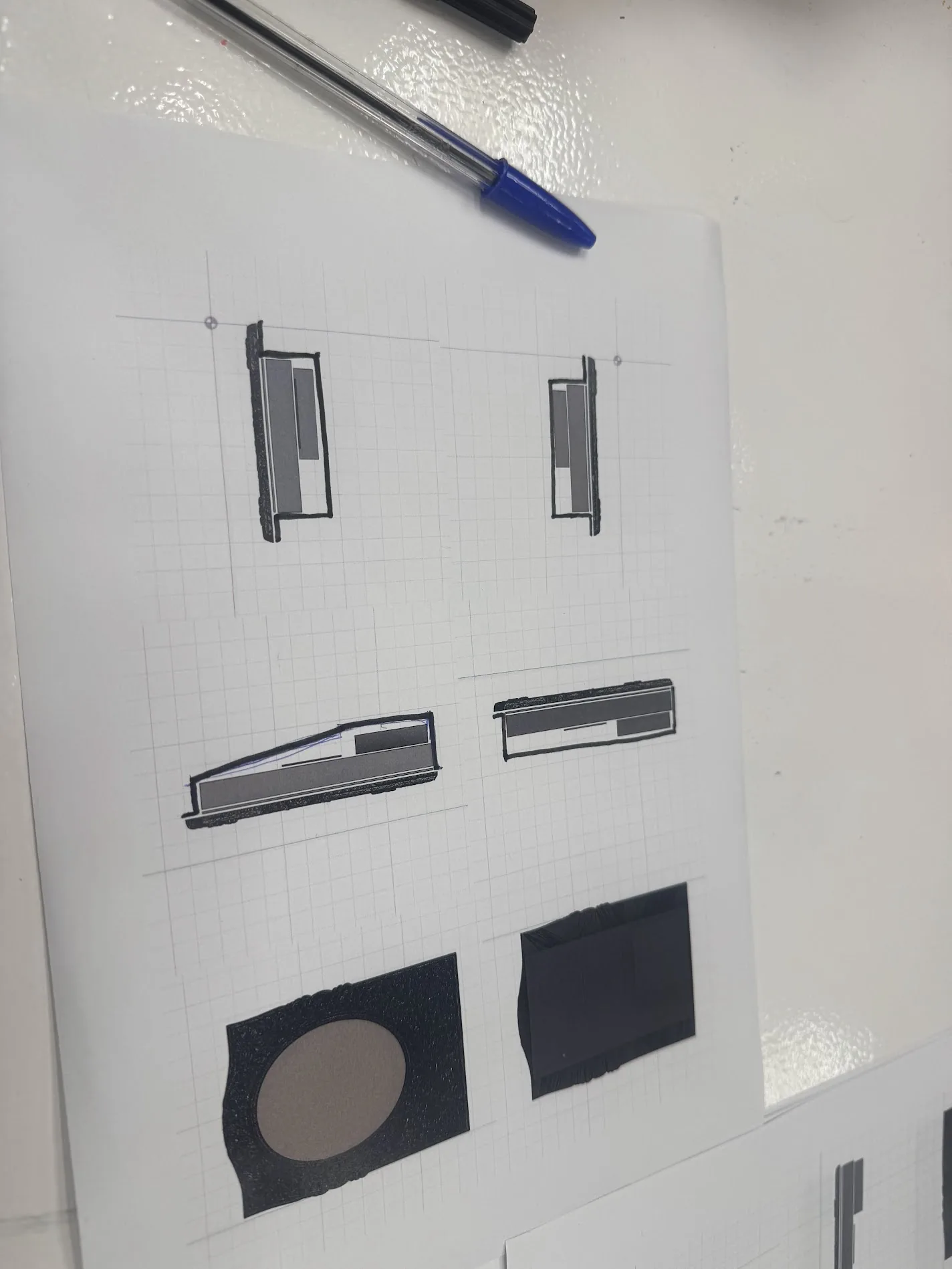 Printed CAD section views of the layered stack with hand-sketching over them in pen