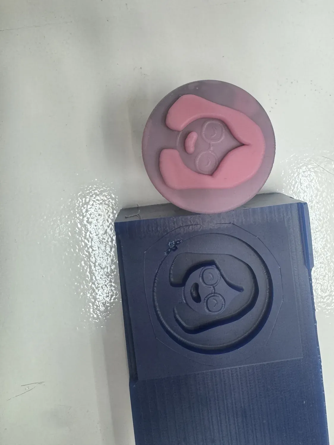 The blue wax avatar mold with the cured pink silicone cast sitting in the recess