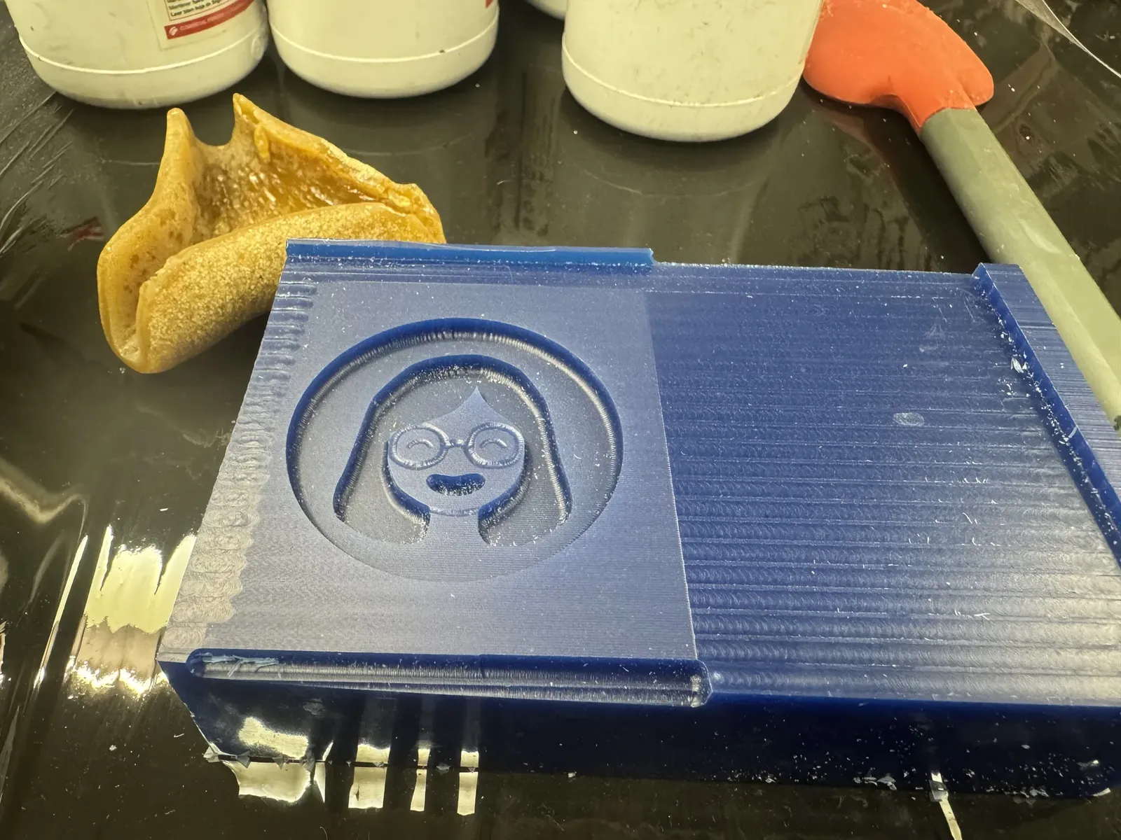 The finished blue machinable-wax mold, avatar face cleanly milled, no cast in it yet