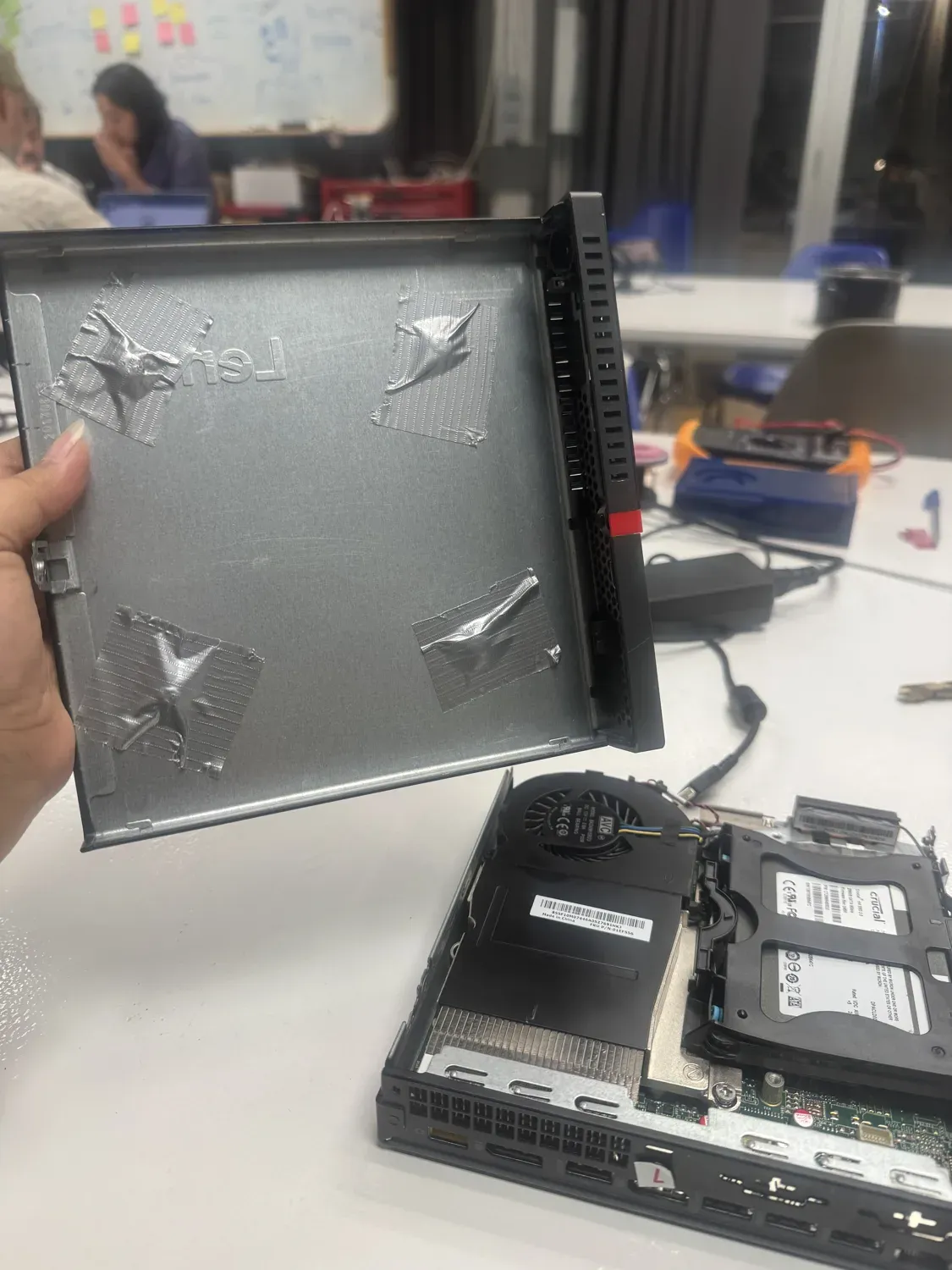 Inside of the mini PC case with tape over the screw heads to protect the internals