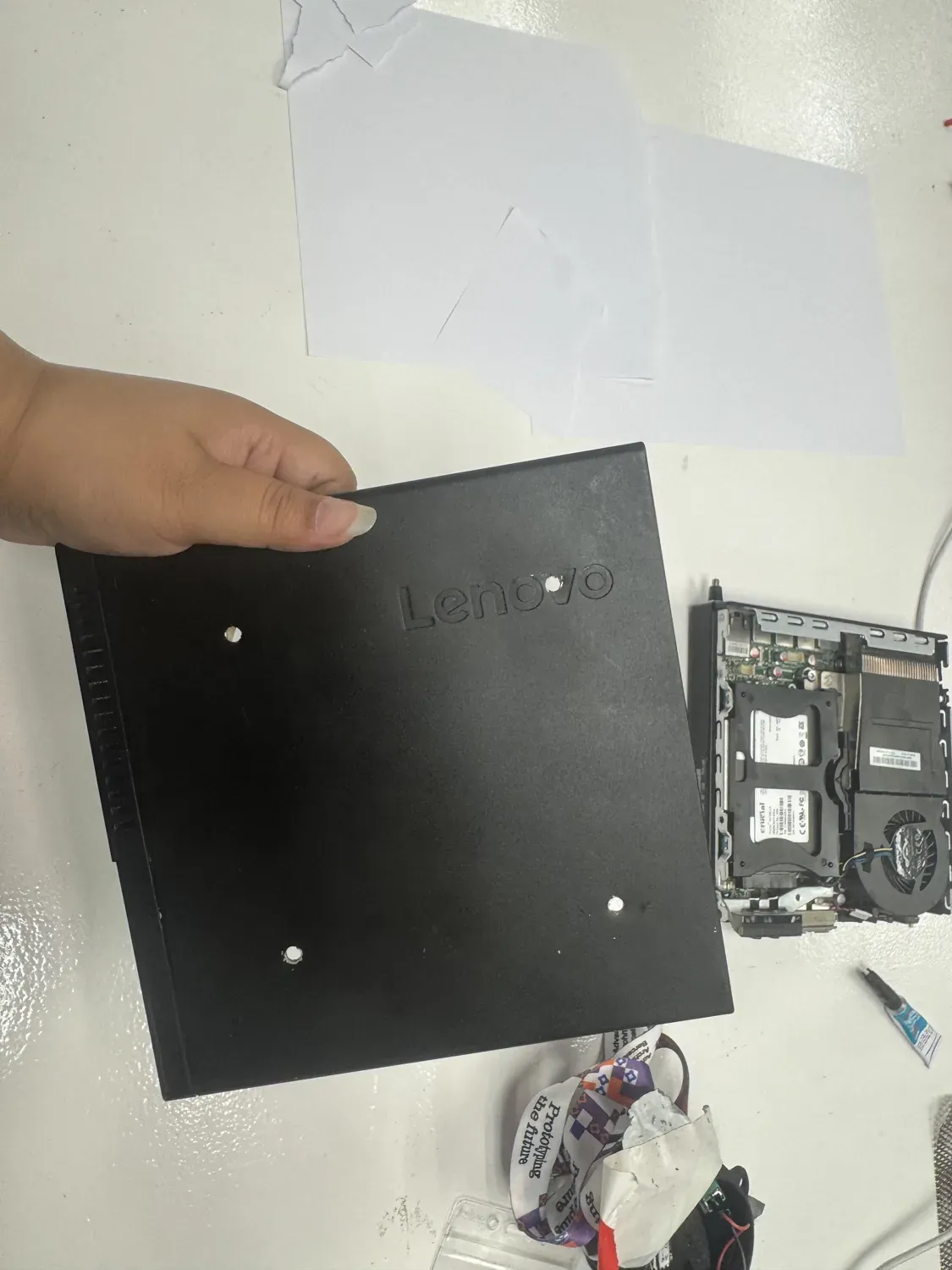 The mini PC case with holes drilled for the VESA pattern