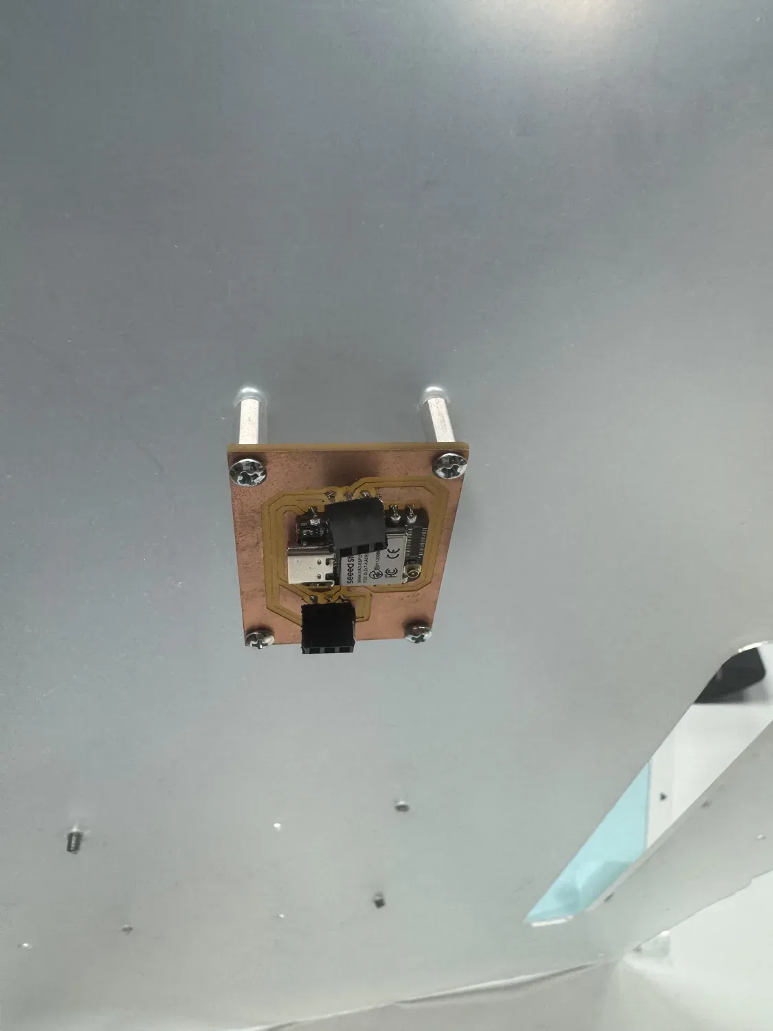 The milled copper sensor node mounted on standoffs through the acrylic panel
