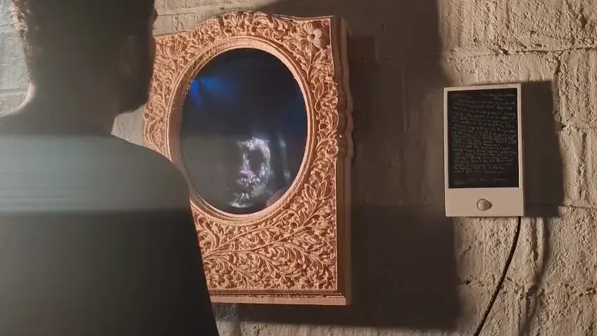 The installed mirror beside the lit letter holder as a viewer approaches