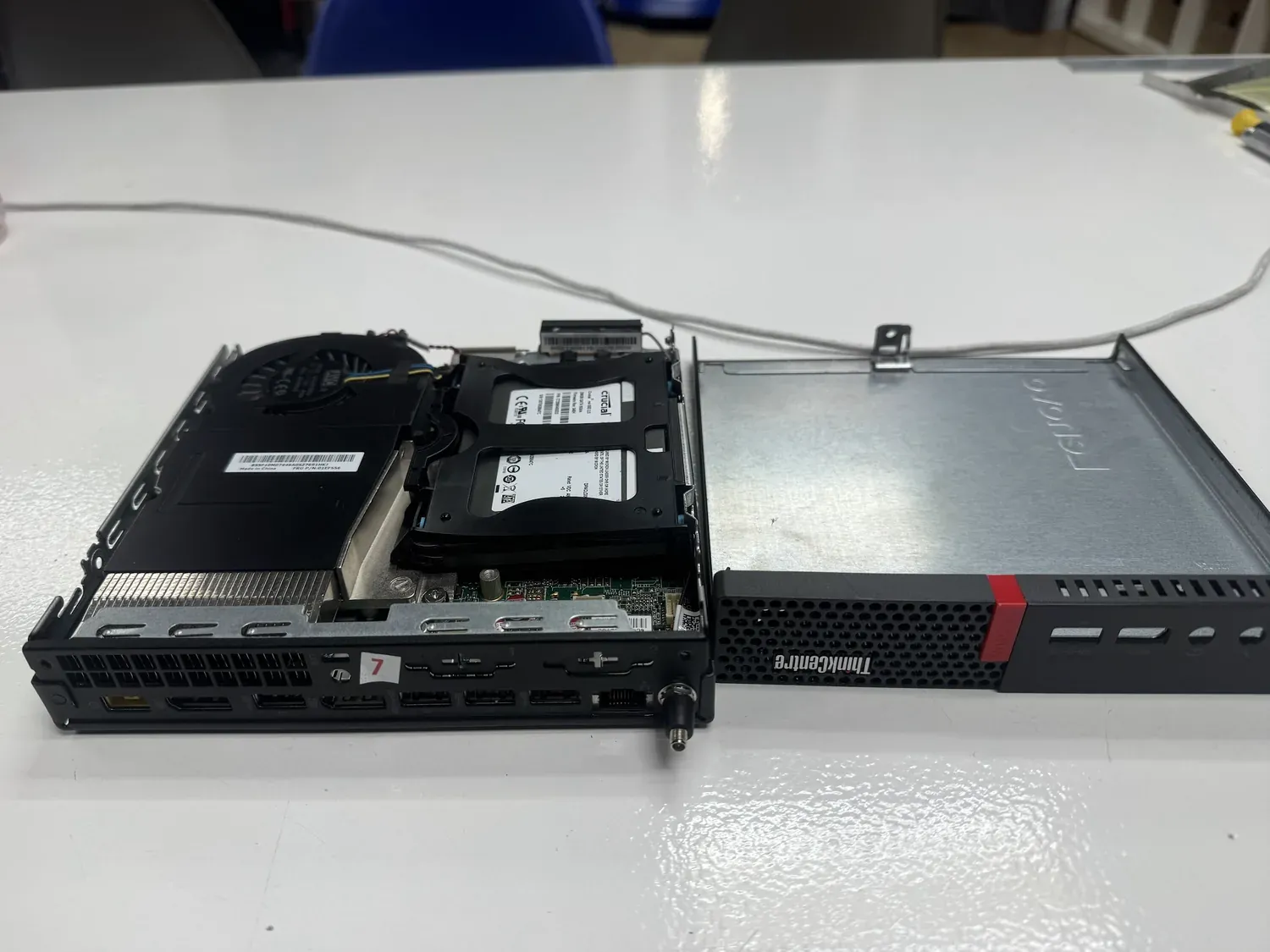 Lenovo ThinkCentre M910q mini PC opened up, cover removed, showing fan, drives and board