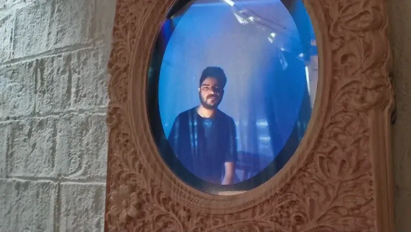 A viewer's face reflected clearly in the oval — the reflection phase