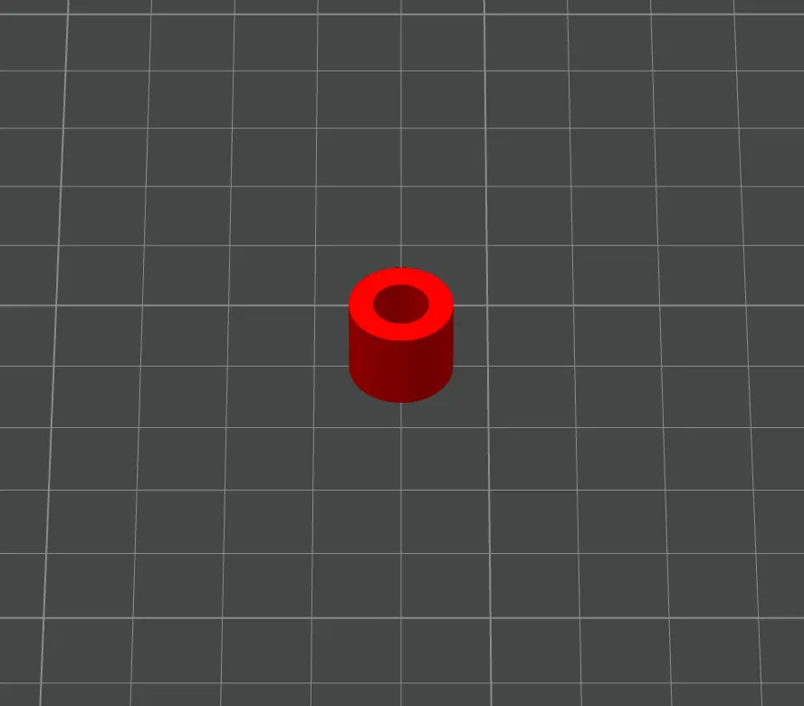 A small red 3D-printed cylindrical spacer with a through-hole