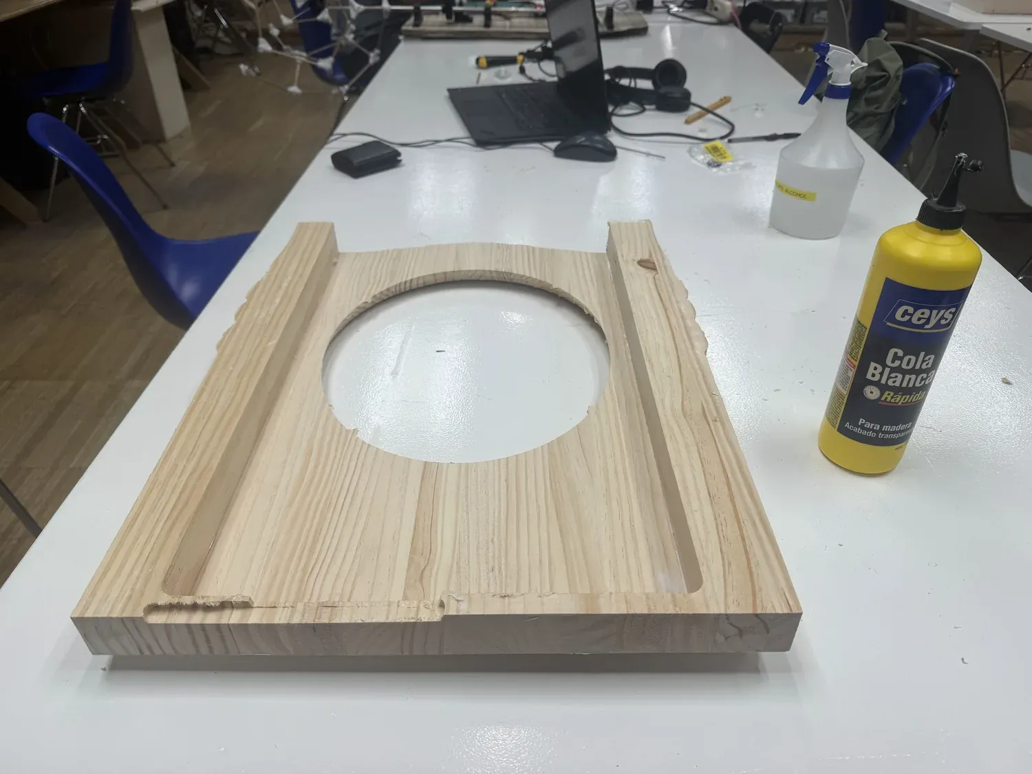 The CNC-pocketed pine body: a recessed central oval opening with side grooves milled into solid pine, next to wood glue