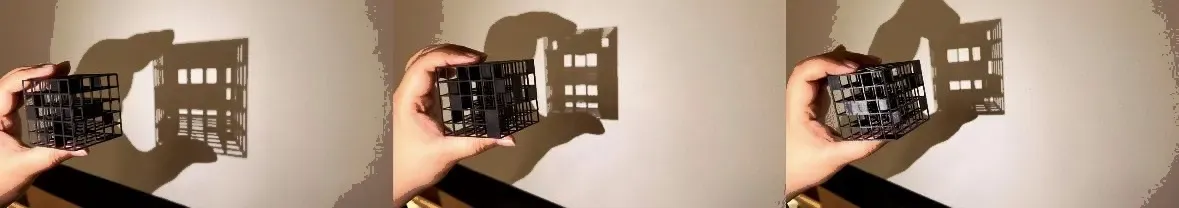 Black resin-printed lattice cube that casts the letters F, A, B as shadows