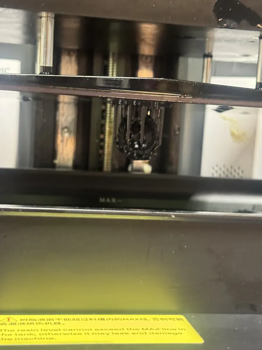 Close-up of the build plate with the cube being printed in resin