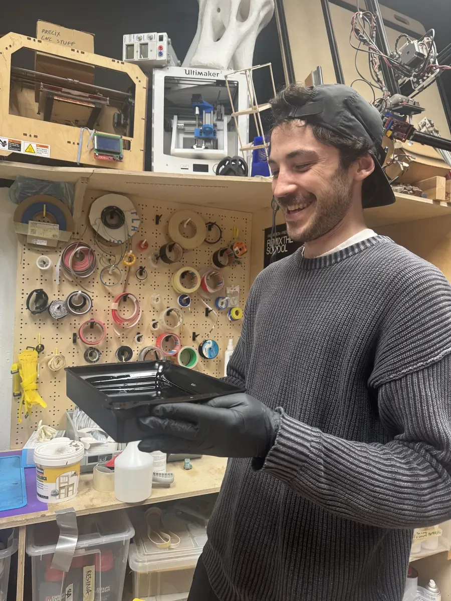 Person in lab holding the resin vat with nitrile gloves