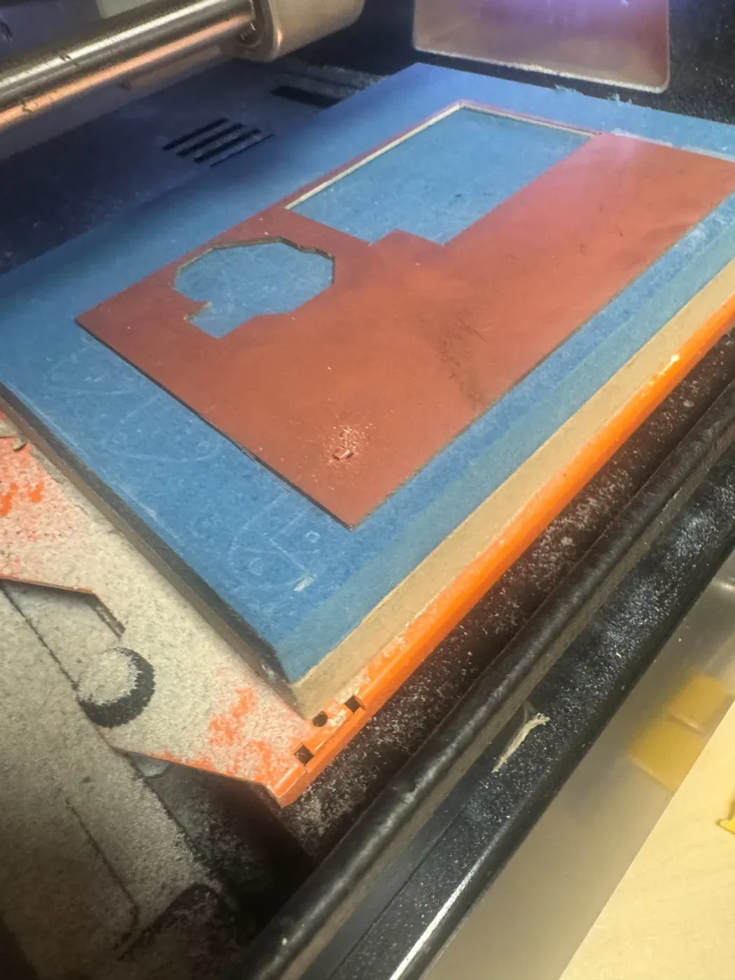 Copper-clad cellulose FR1 PCB stock in the laser cutter bed