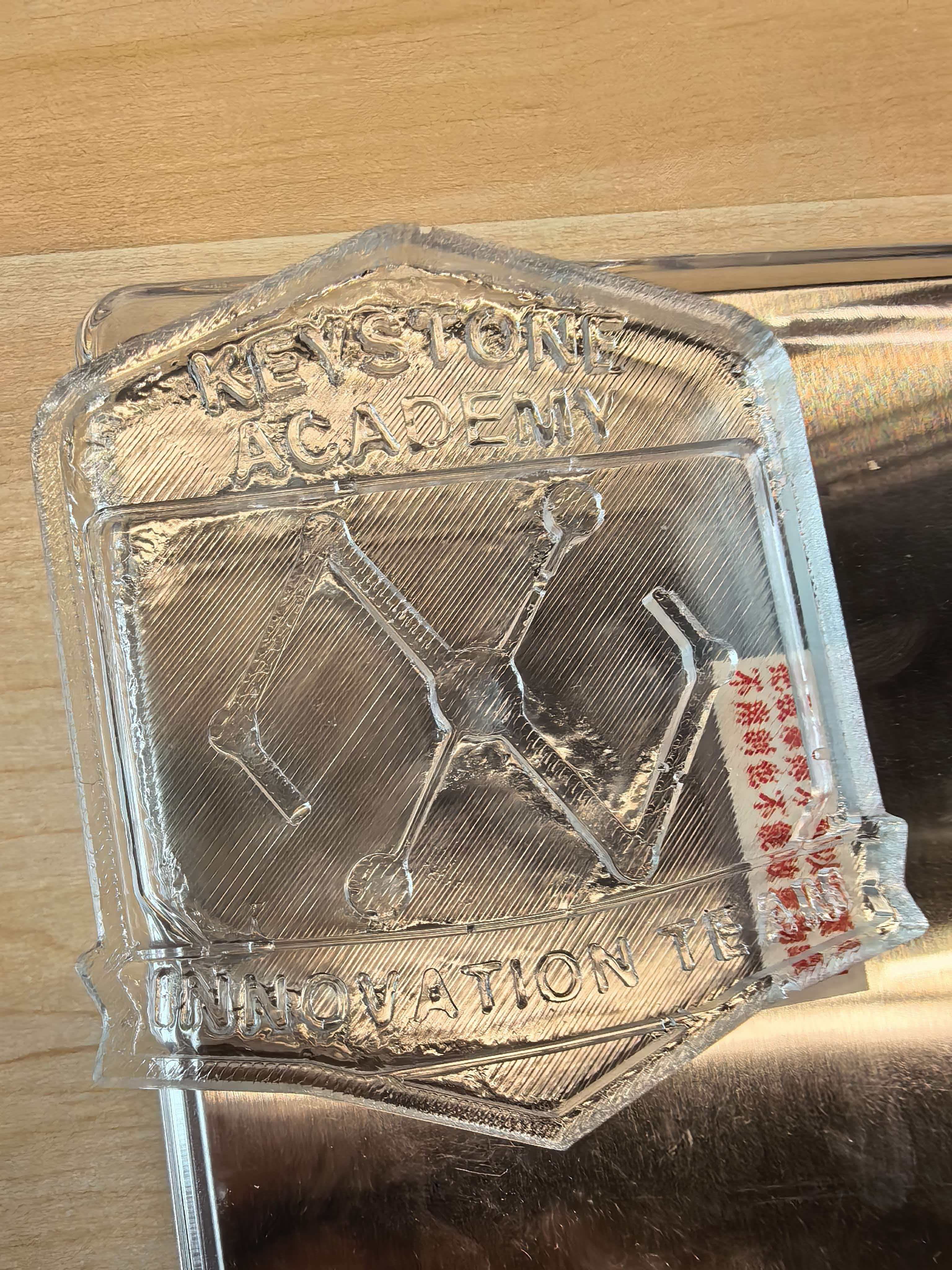 Clear resin cast Innovation Department badge showing Keystone Academy text and logo