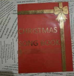 Holiday song book with cut and foiled elements