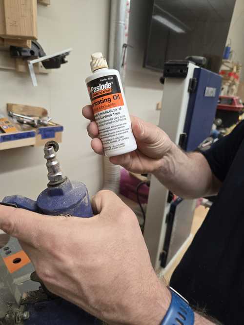 Paslode lubricating oil being applied to the brad gun inlet