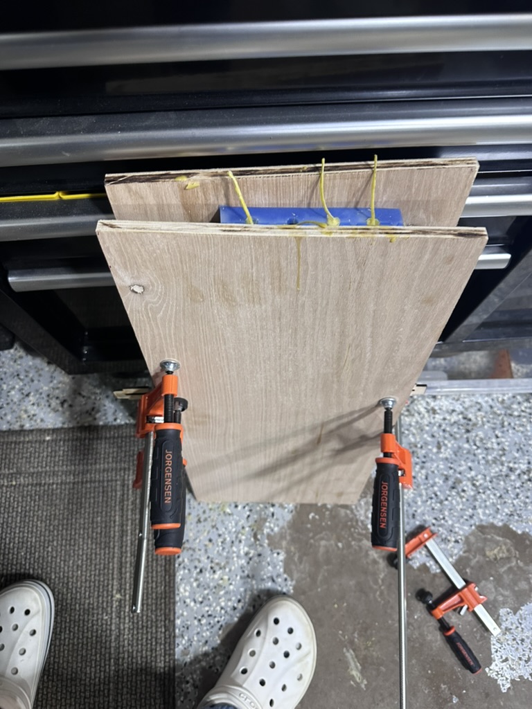 Silicone mold halves clamped between wood boards during the beeswax pour