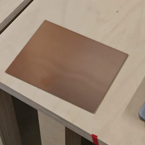 Blank copper clad FR1 board on the machine bed